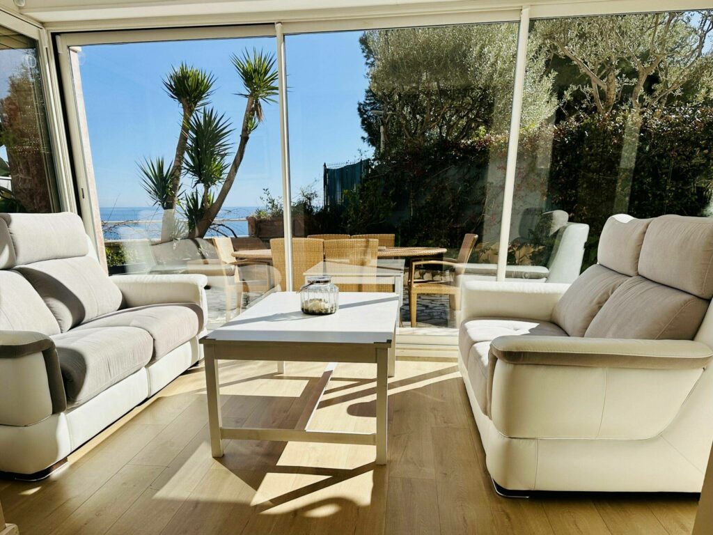 Salon avec canapés clairs et vue panoramique sur la mer depuis les baies vitrées – Cap d'Ail Monaco