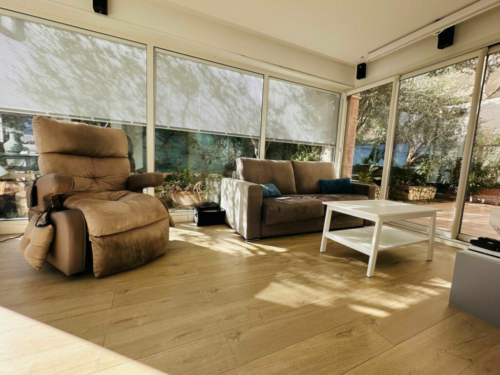 Salon avec fauteuil relax, canapé et grandes baies vitrées ouvrant sur la terrasse – appartement Cap d'Ail près de Monaco