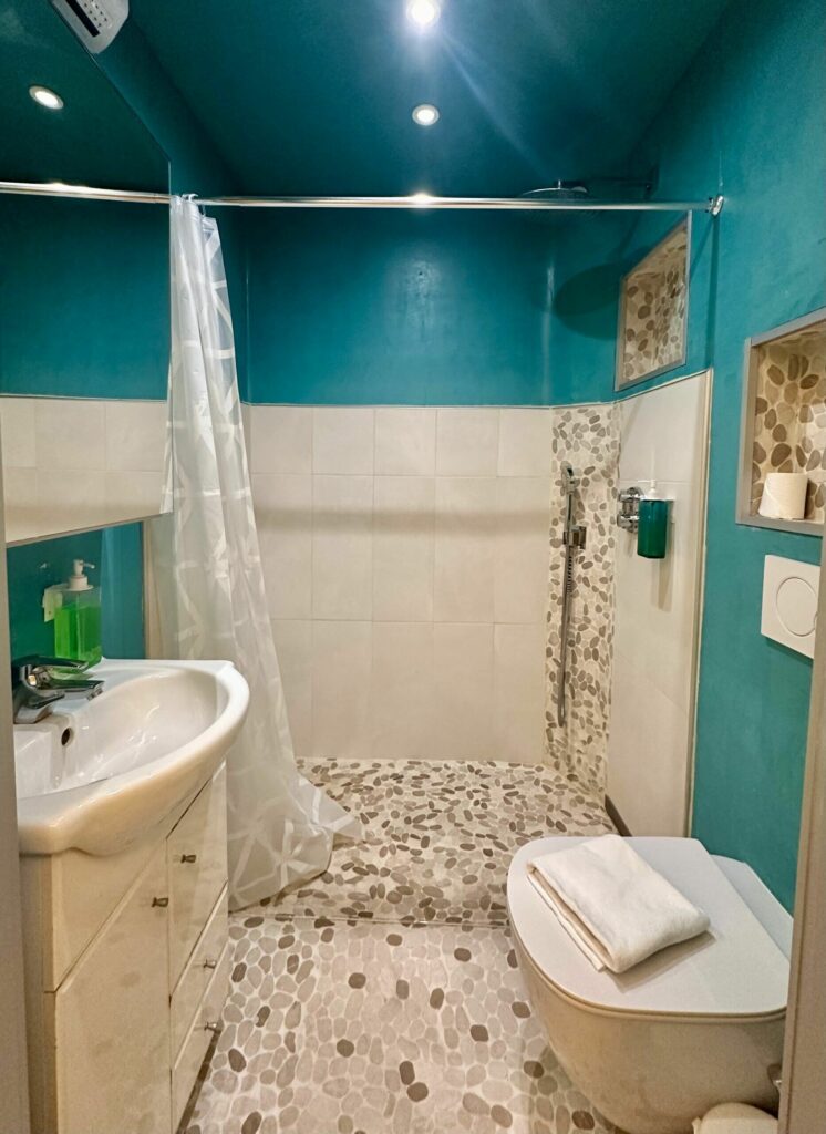 Salle de bain turquoise avec douche à l'italienne, lavabo et WC – appartement Cap d'Ail Monaco