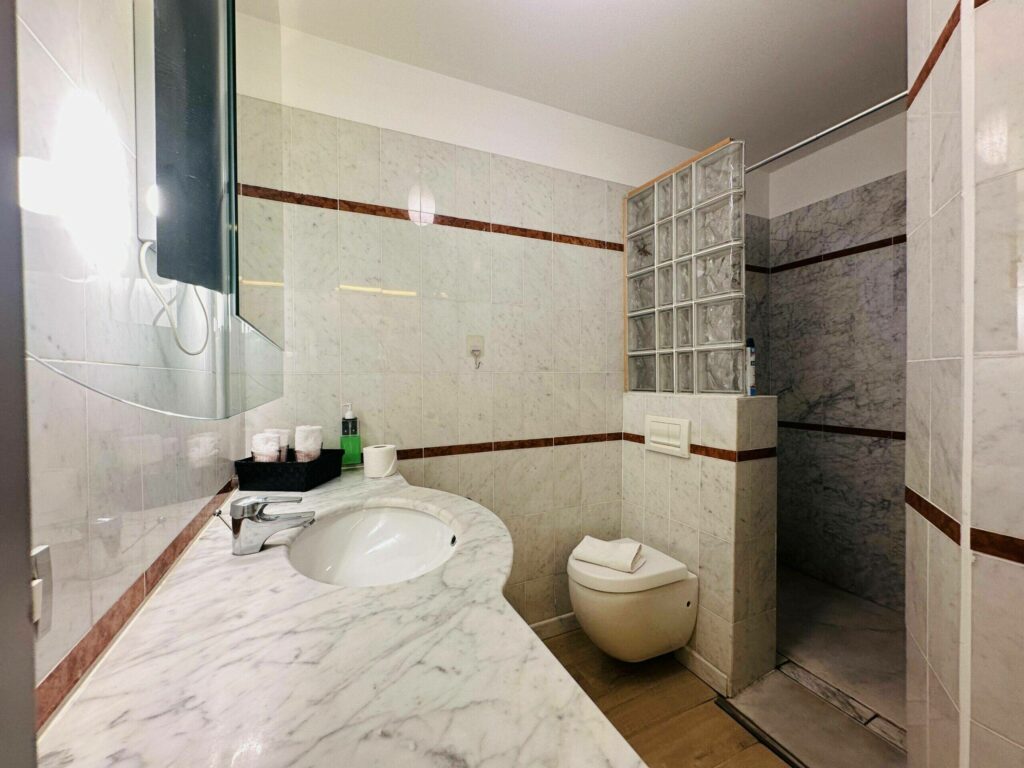 Salle de bain en marbre avec douche, lavabo et WC – location saisonnière Cap d'Ail Monaco